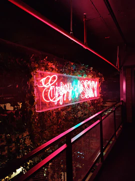 Illuminated 3D sign with black and cyan colors glowing in a modern office environment