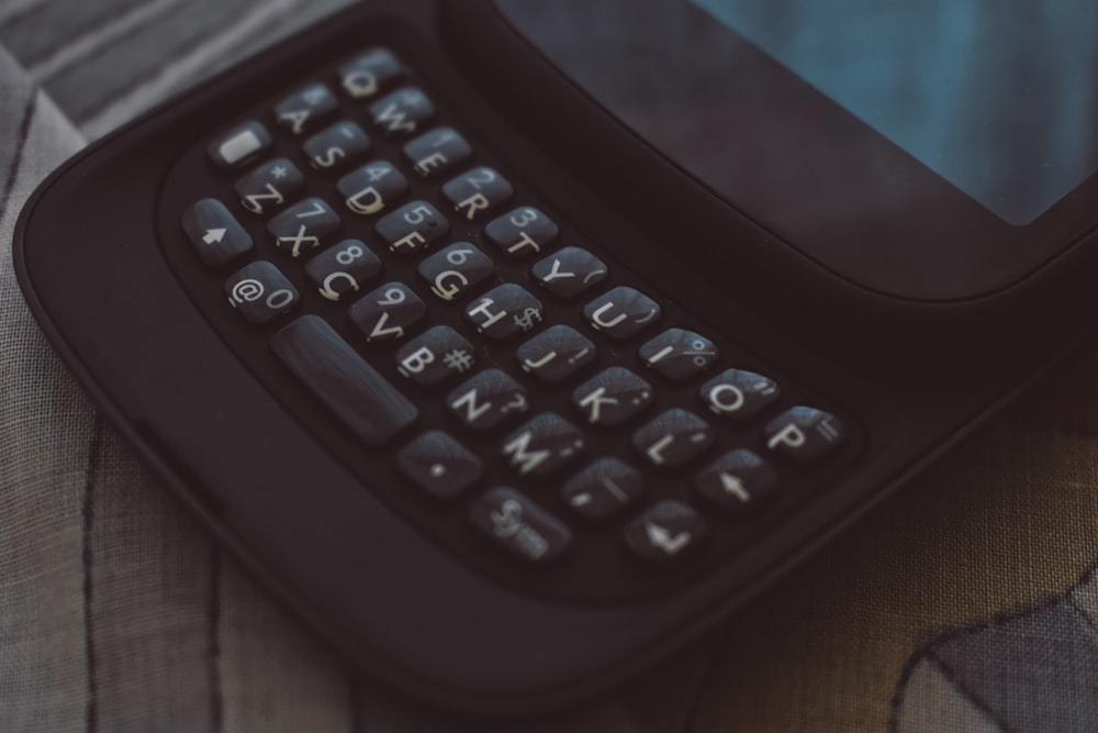 a black calculator on a blue surface