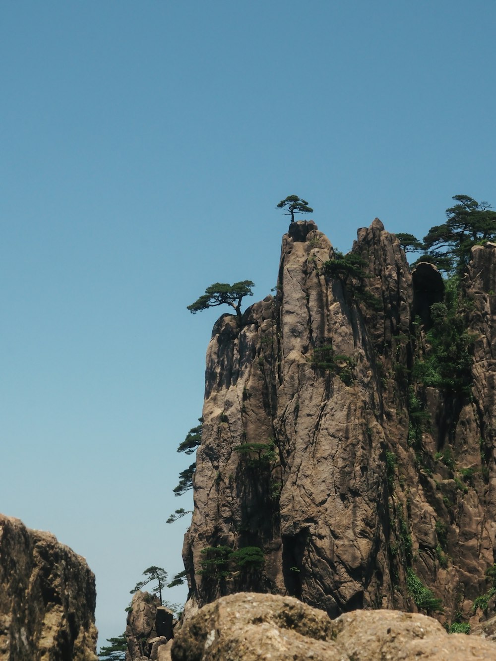 a rocky cliff with a cross on top