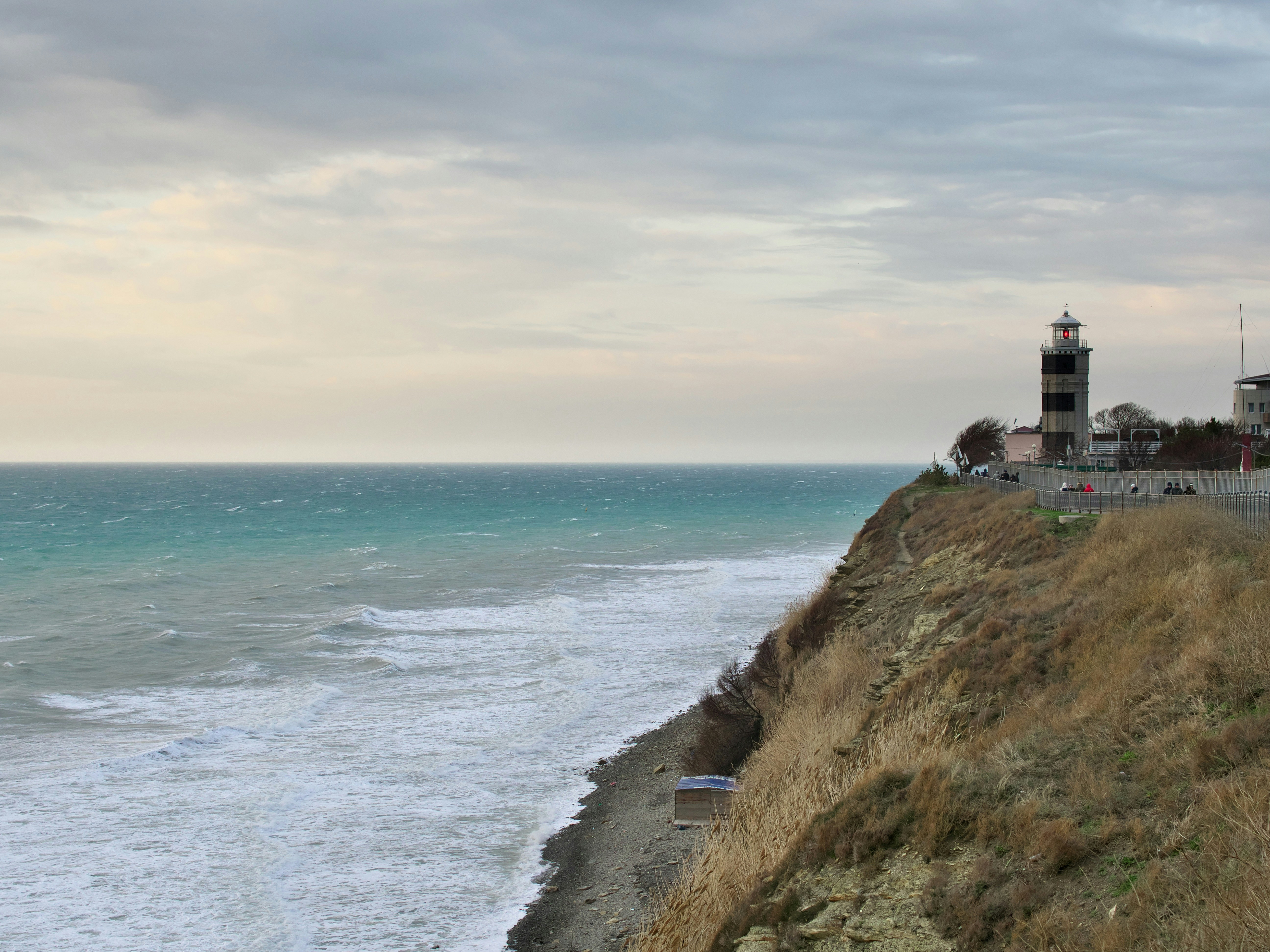 a lighthouse on a hill by the ocean