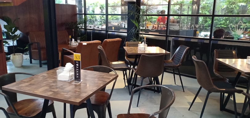 Interior shot of the café showing sleek wooden tables and deep green accents.