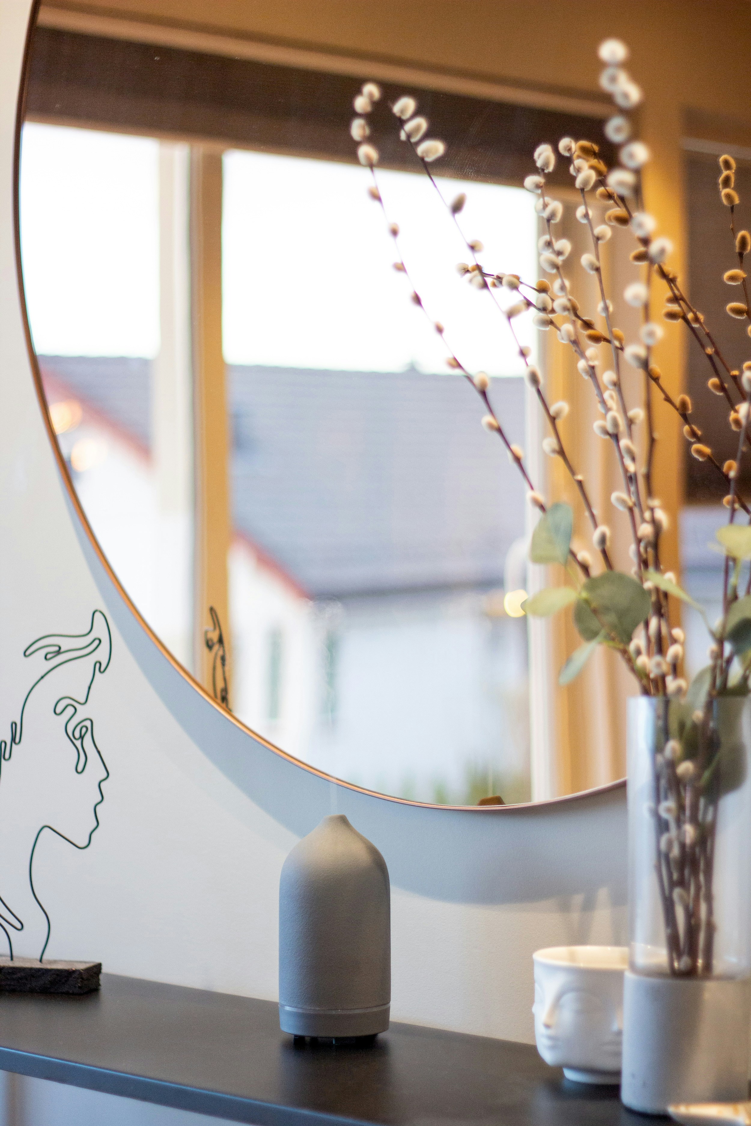 eine Vase mit Blumen vor einem Fenster