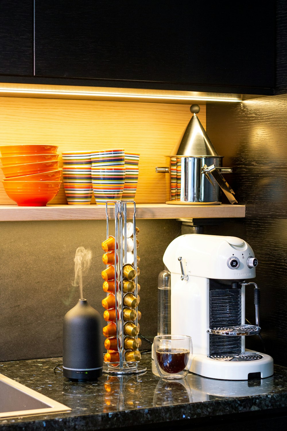 a coffee maker and a glass of wine on a counter