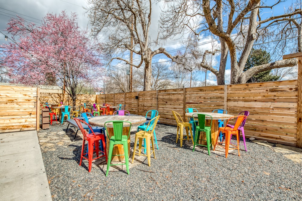 a group of colorful tables and chairs outside