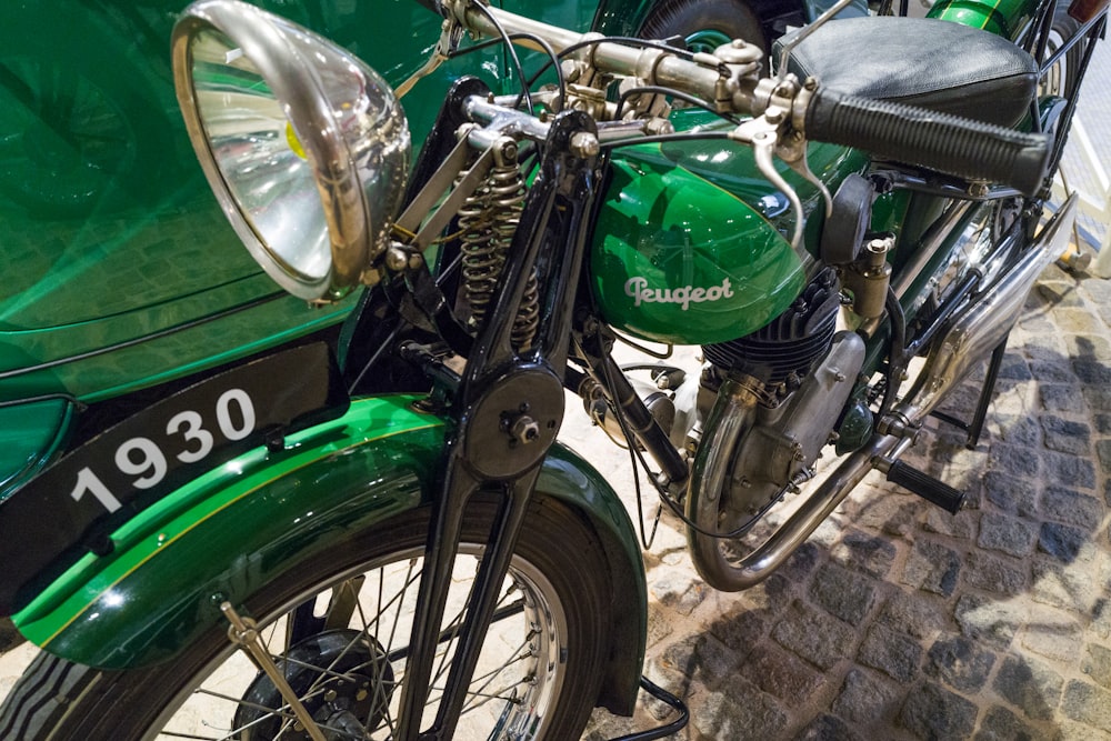 a green motorcycle parked on a stone surface