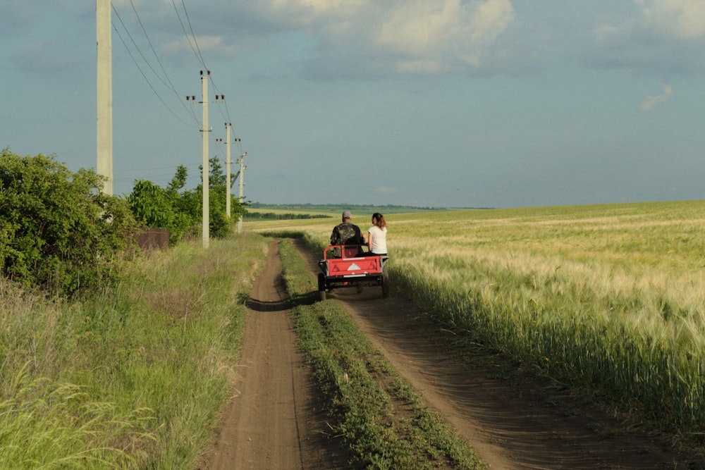 a group of people riding a small train on a dirt road