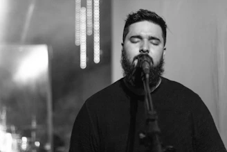 Tony singing into a vintage microphone, his long white beard catching the soft amber light.