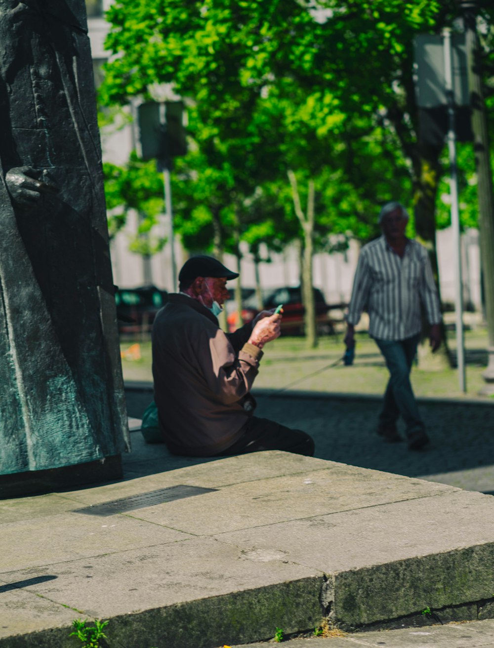 a person sitting on a sidewalk