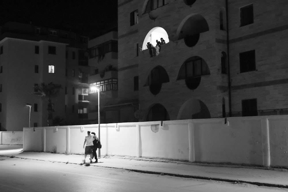 a couple of people standing on a street corner