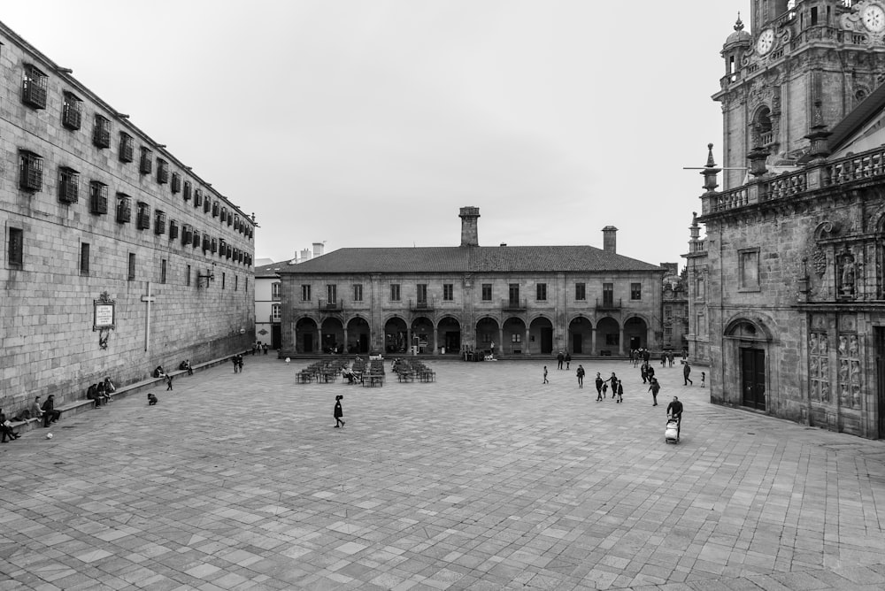 a group of people walking in a courtyard between buildings