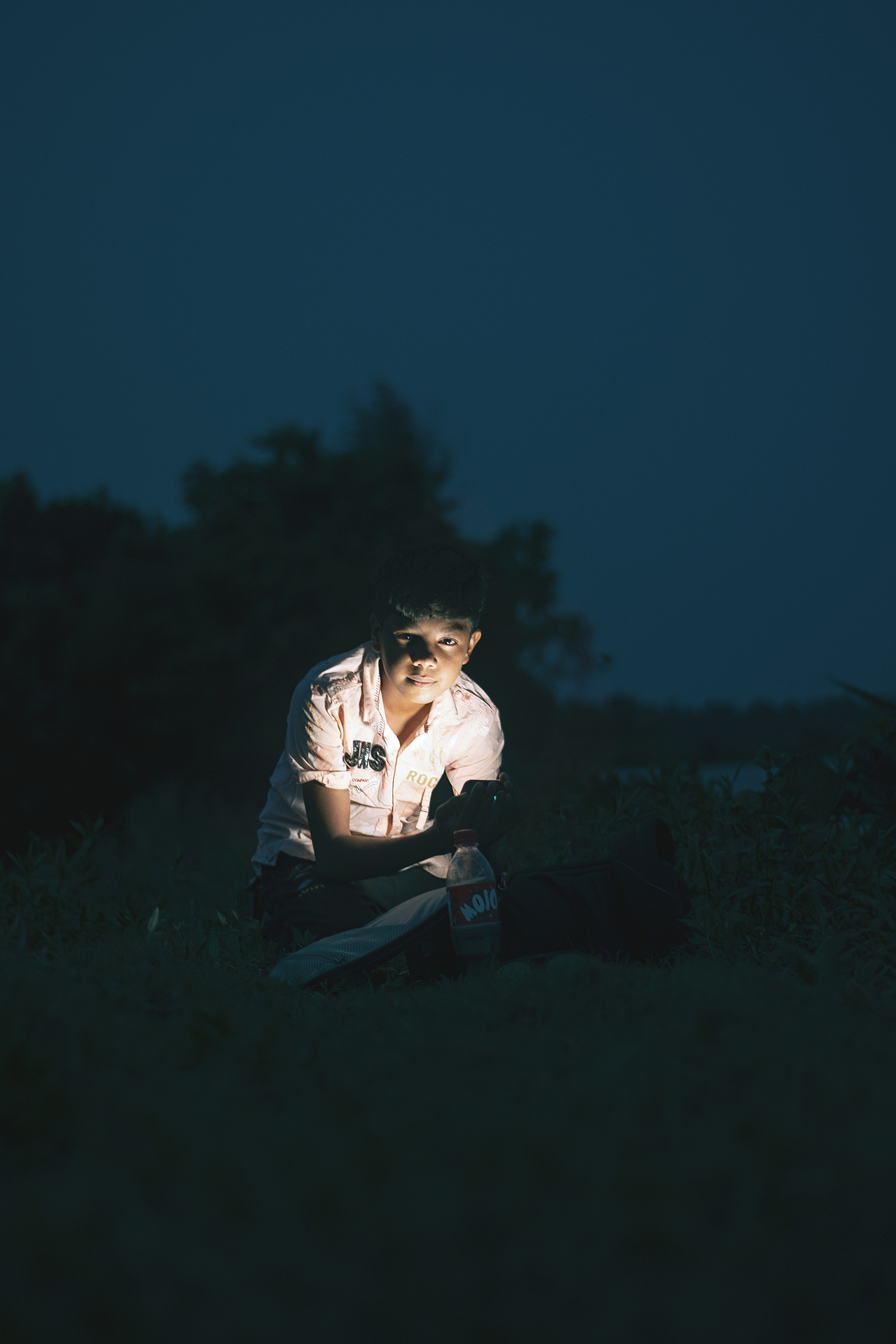 a person sitting on a bench at night