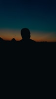 A silhouette of a police officer against a sunset backdrop.