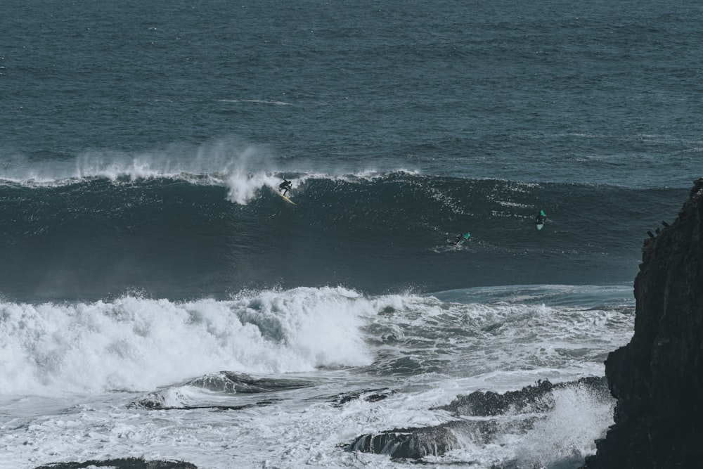 a group of surfers riding a wave