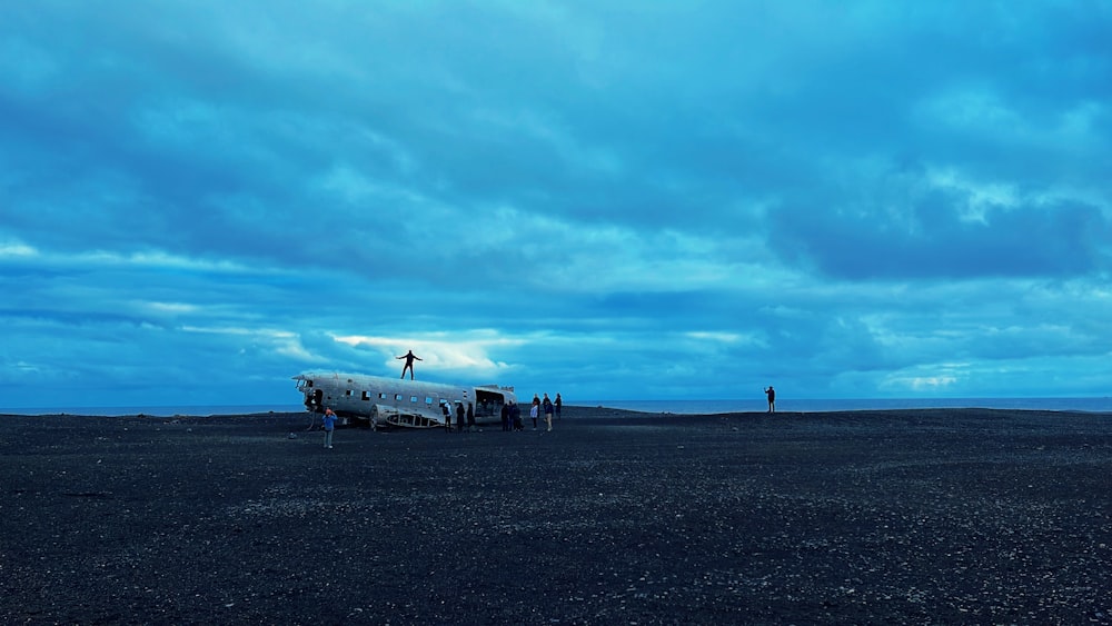 대형 비행기 옆 해변에 서 있는 한 무리의 사람들