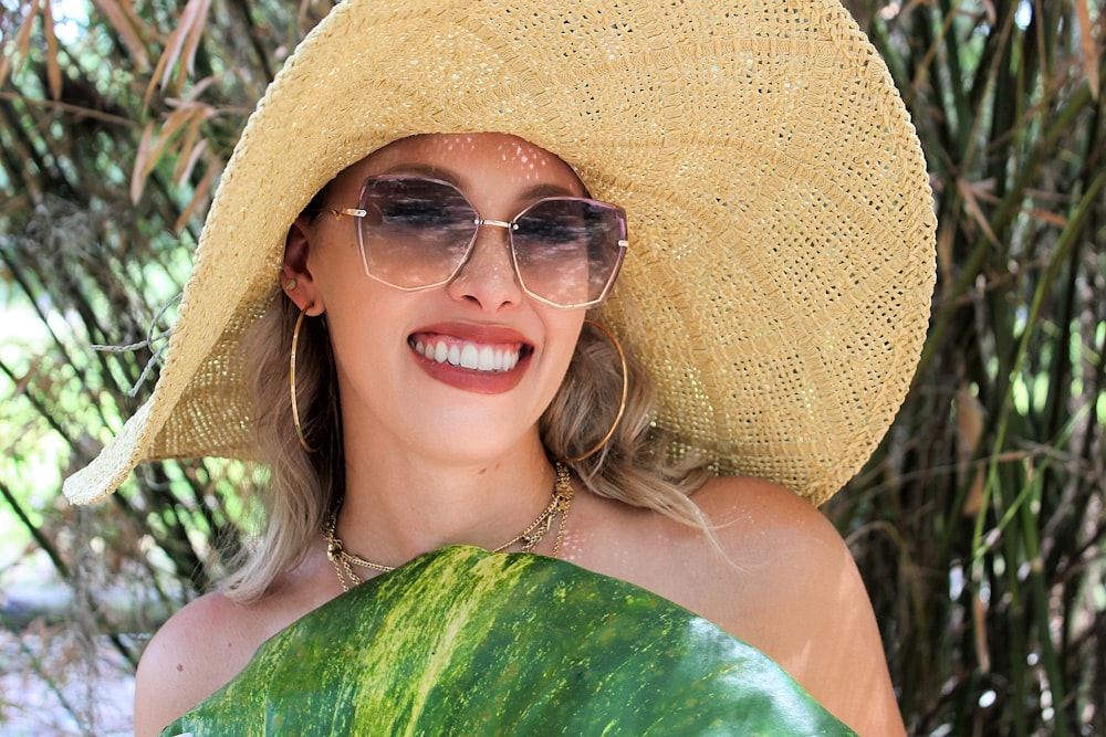 uma mulher que usa um chapéu e óculos de sol