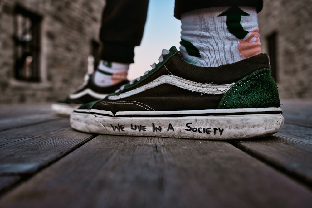 a pair of feet wearing green and white sneakers