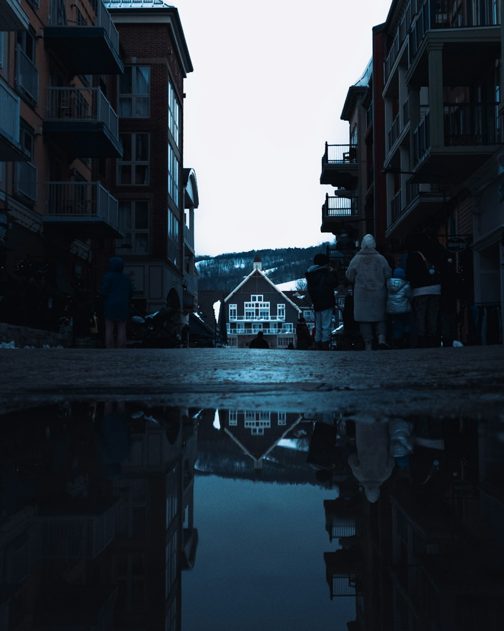 a group of people standing on a bridge over a body of water