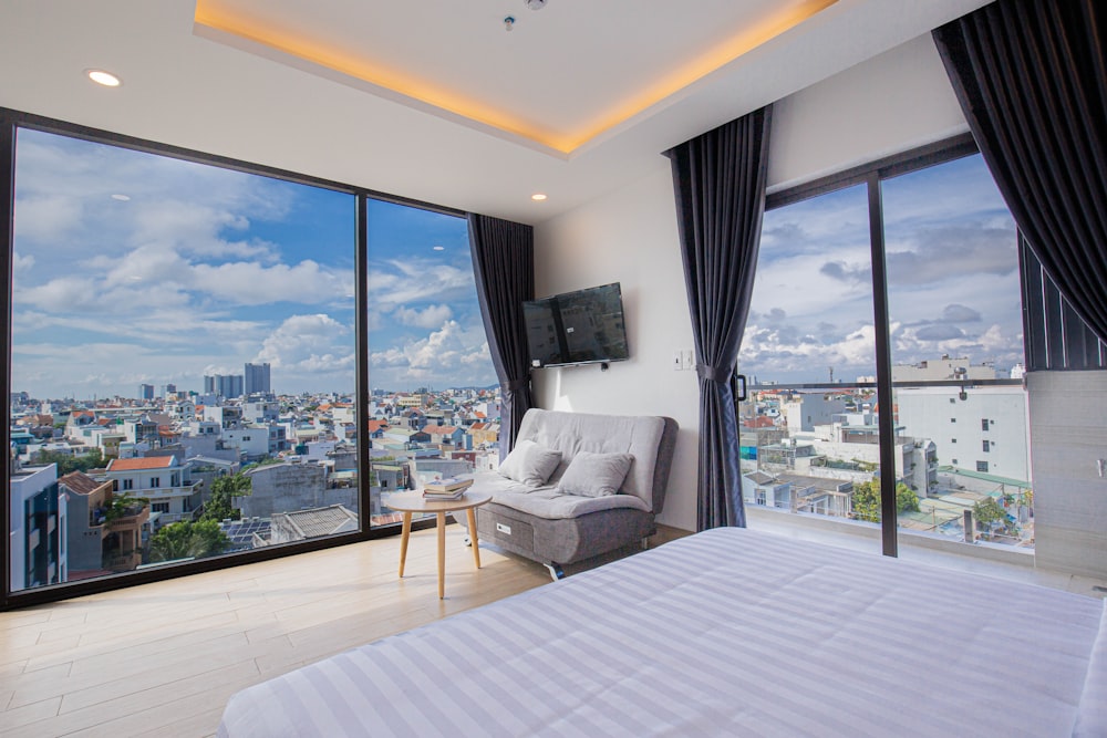 una habitación con una ventana grande y un sofá y una mesa con TV y vistas a