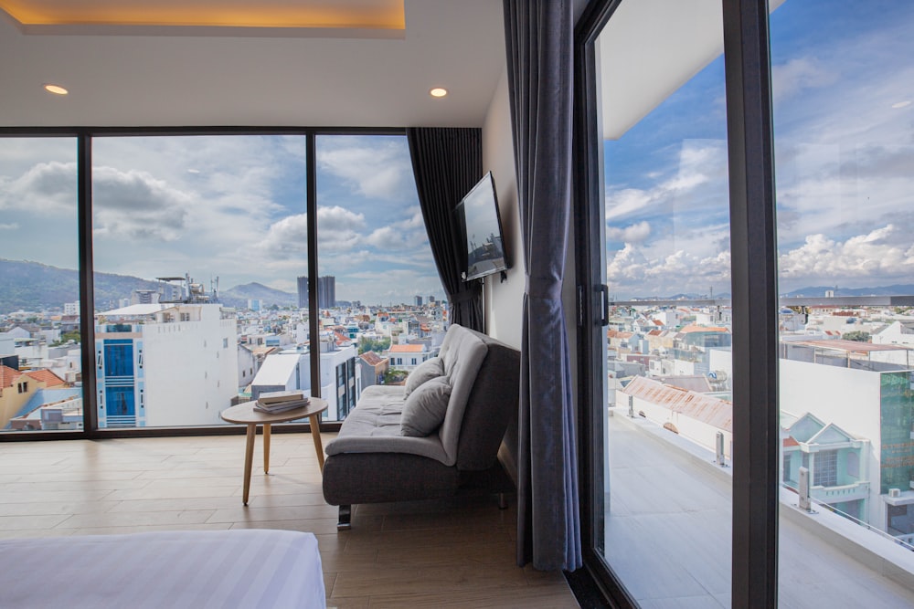 a room with a couch and a window with a view of a city