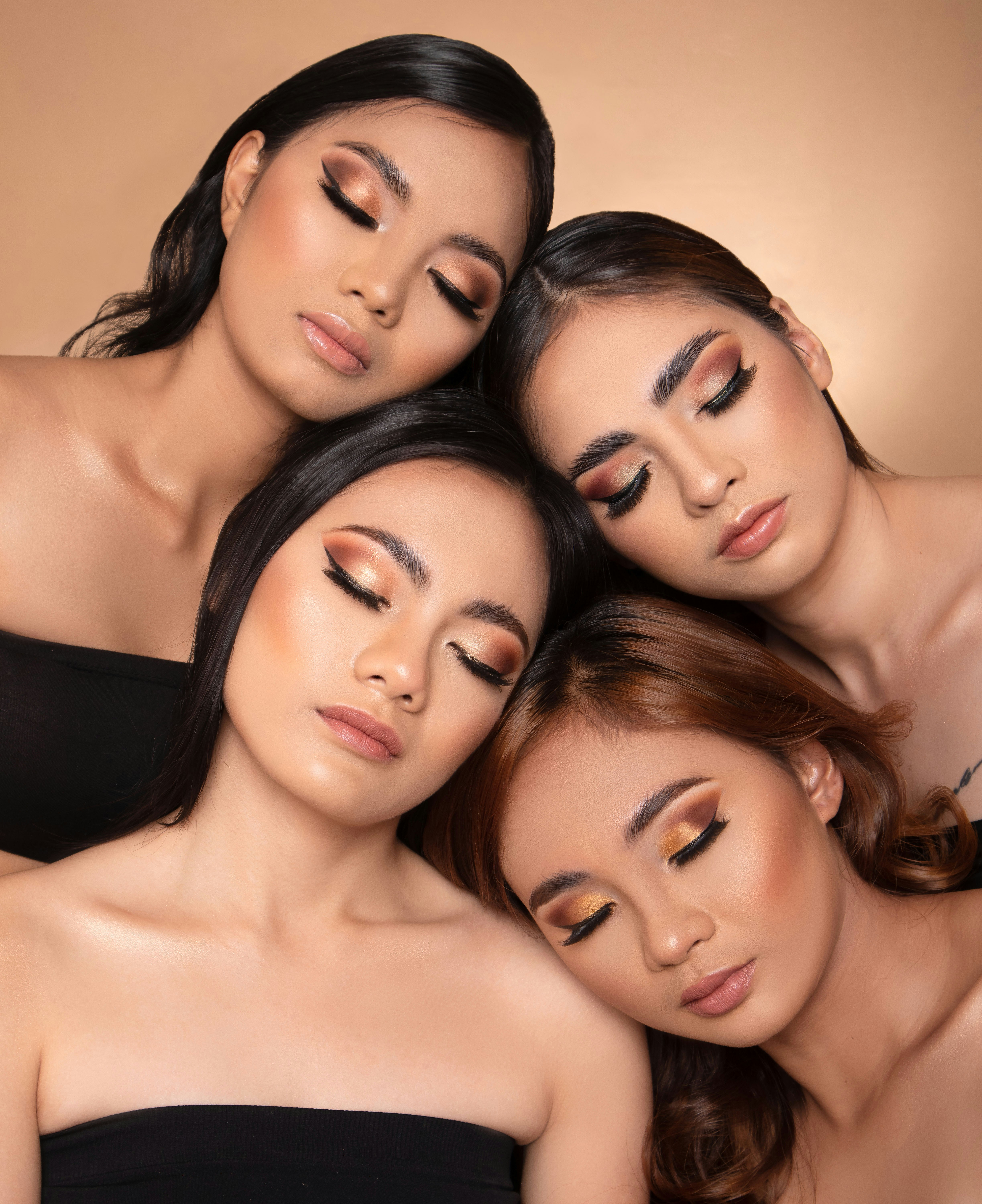 Four women with eyes closed and makeup on