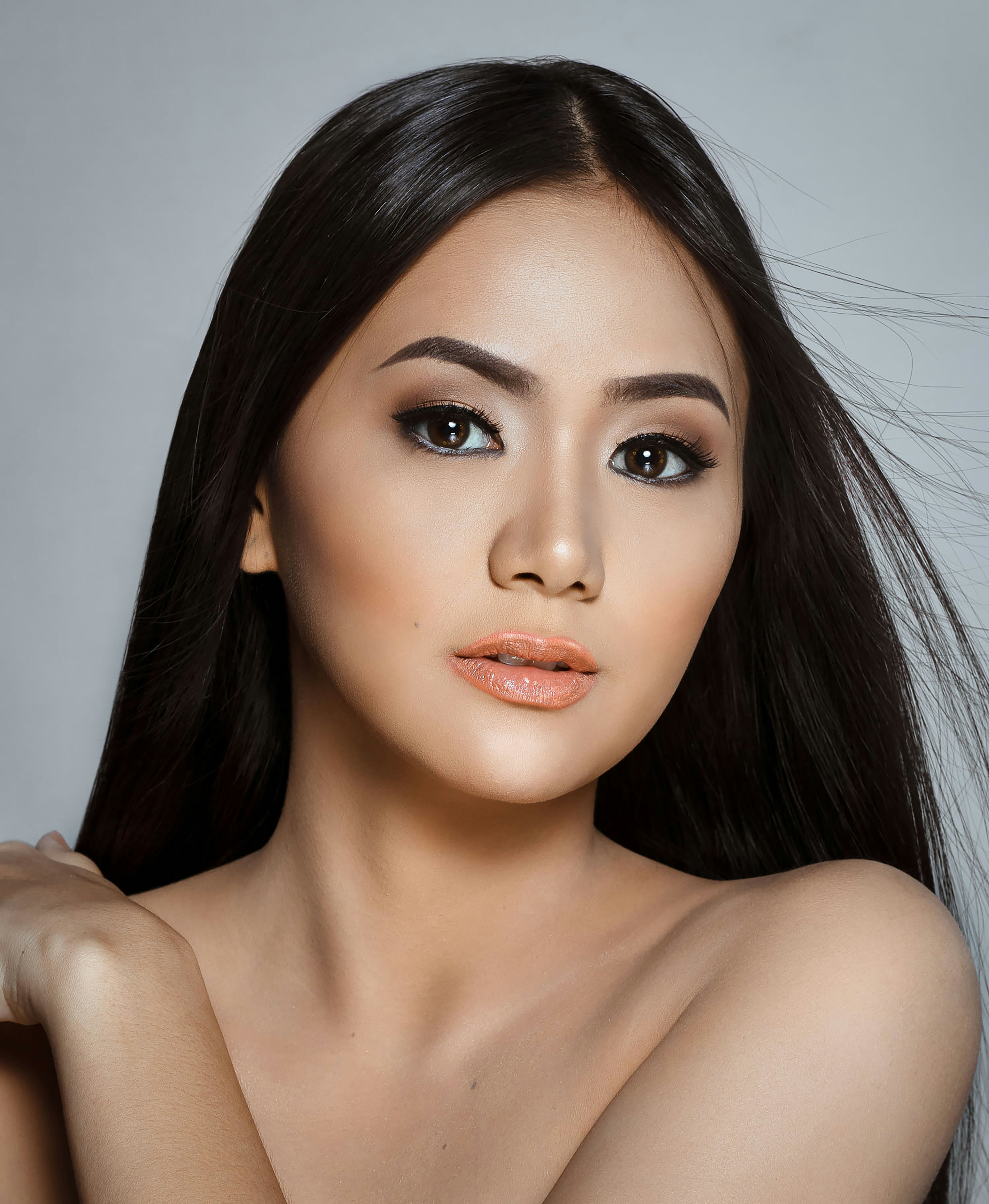 A young woman with long dark hair and makeup
