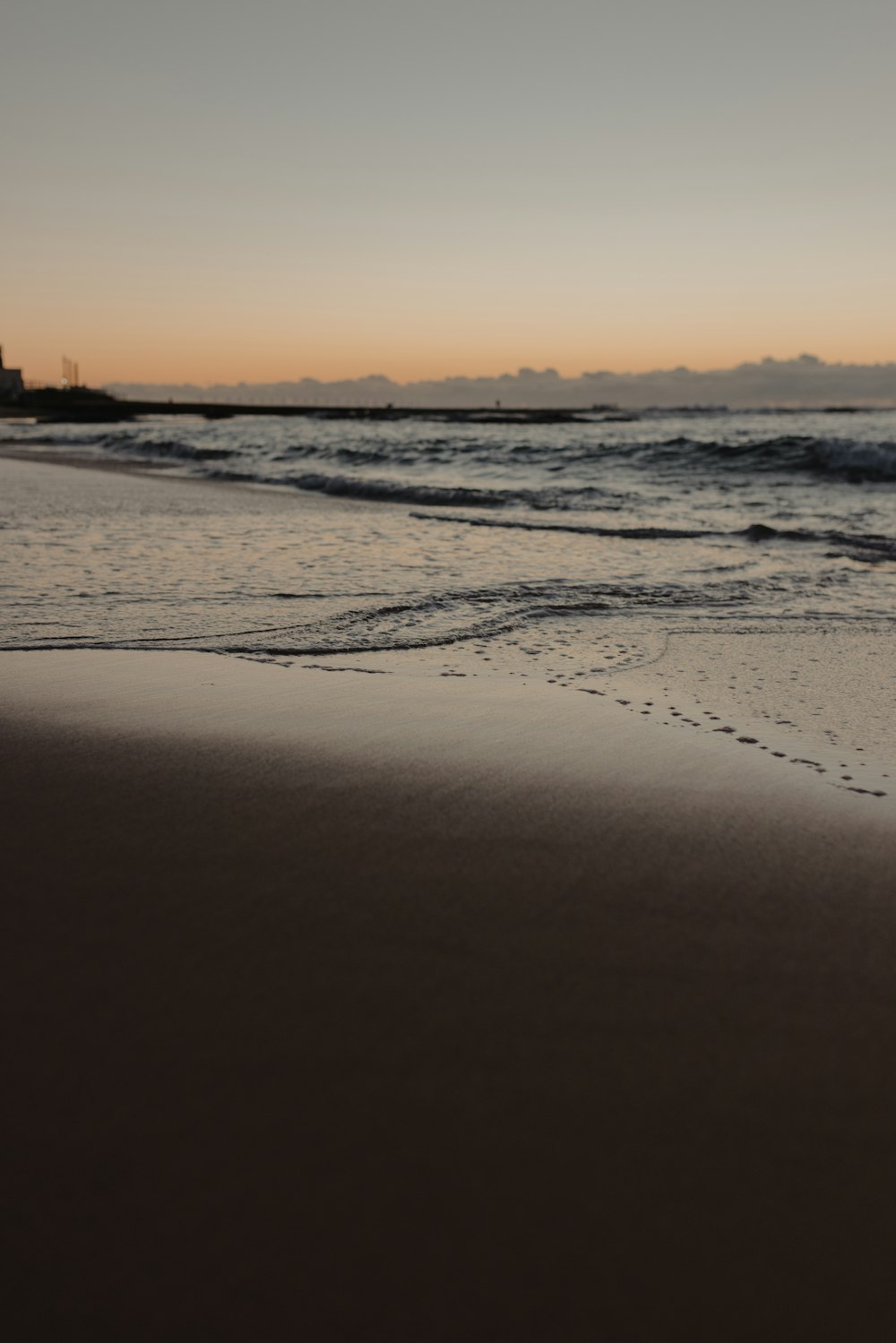 a beach with waves and a sunset