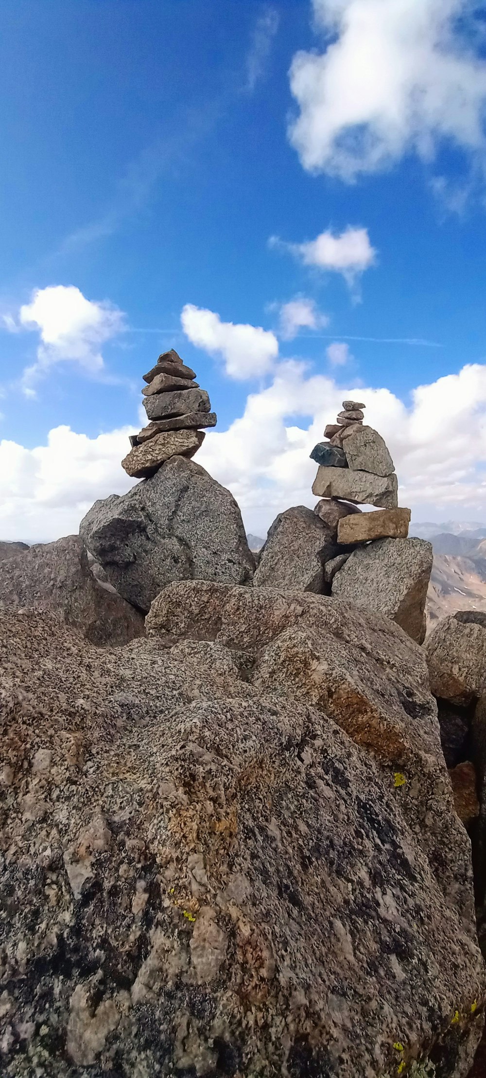 a group of rocks with a blue sky and clouds