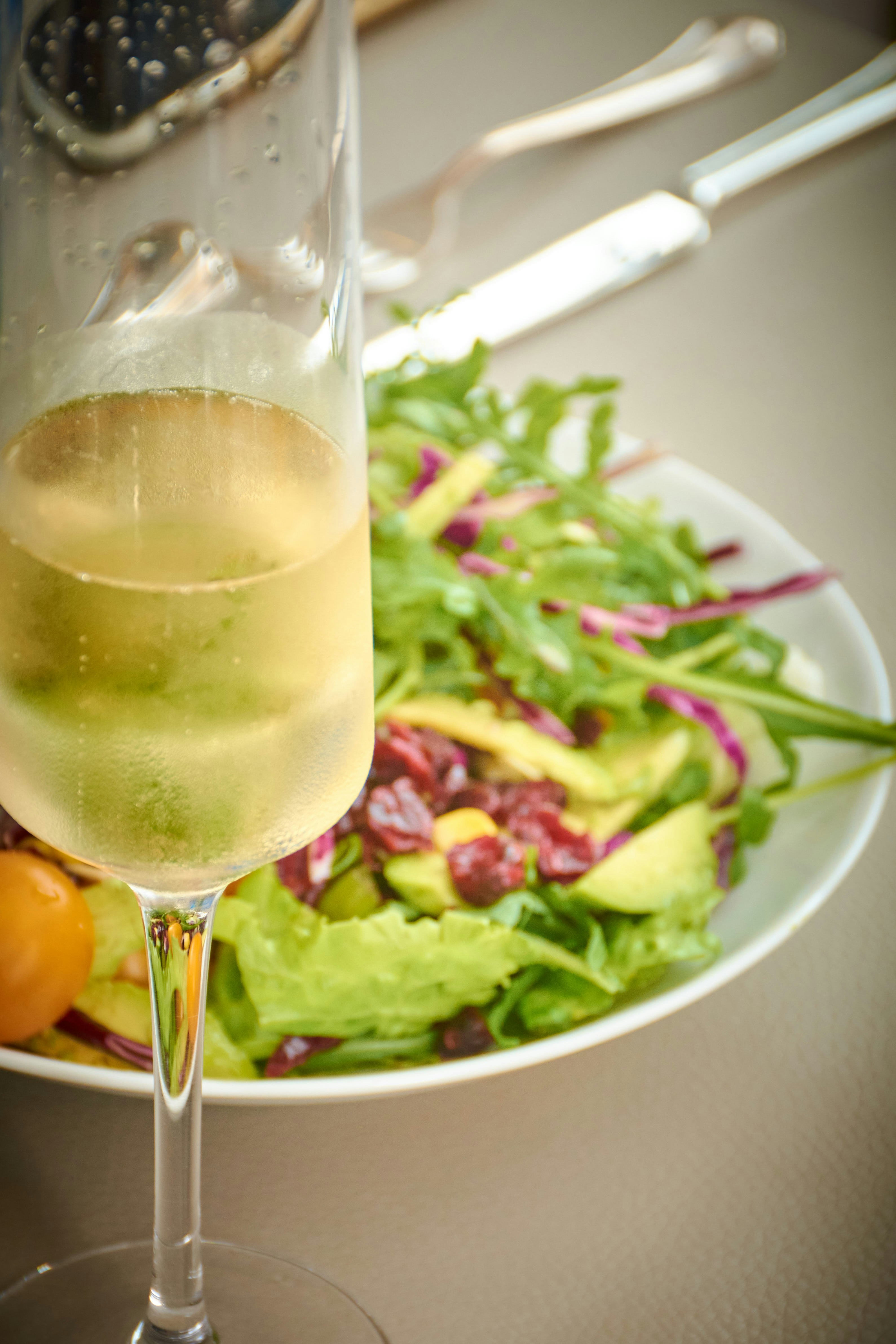 Une coupe de champagne à côté d’une salade