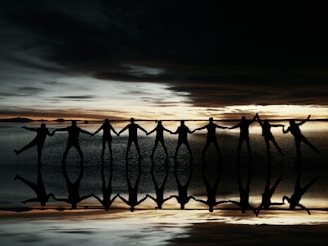 A sunset silhouette of children holding hands, symbolizing unity and hope.