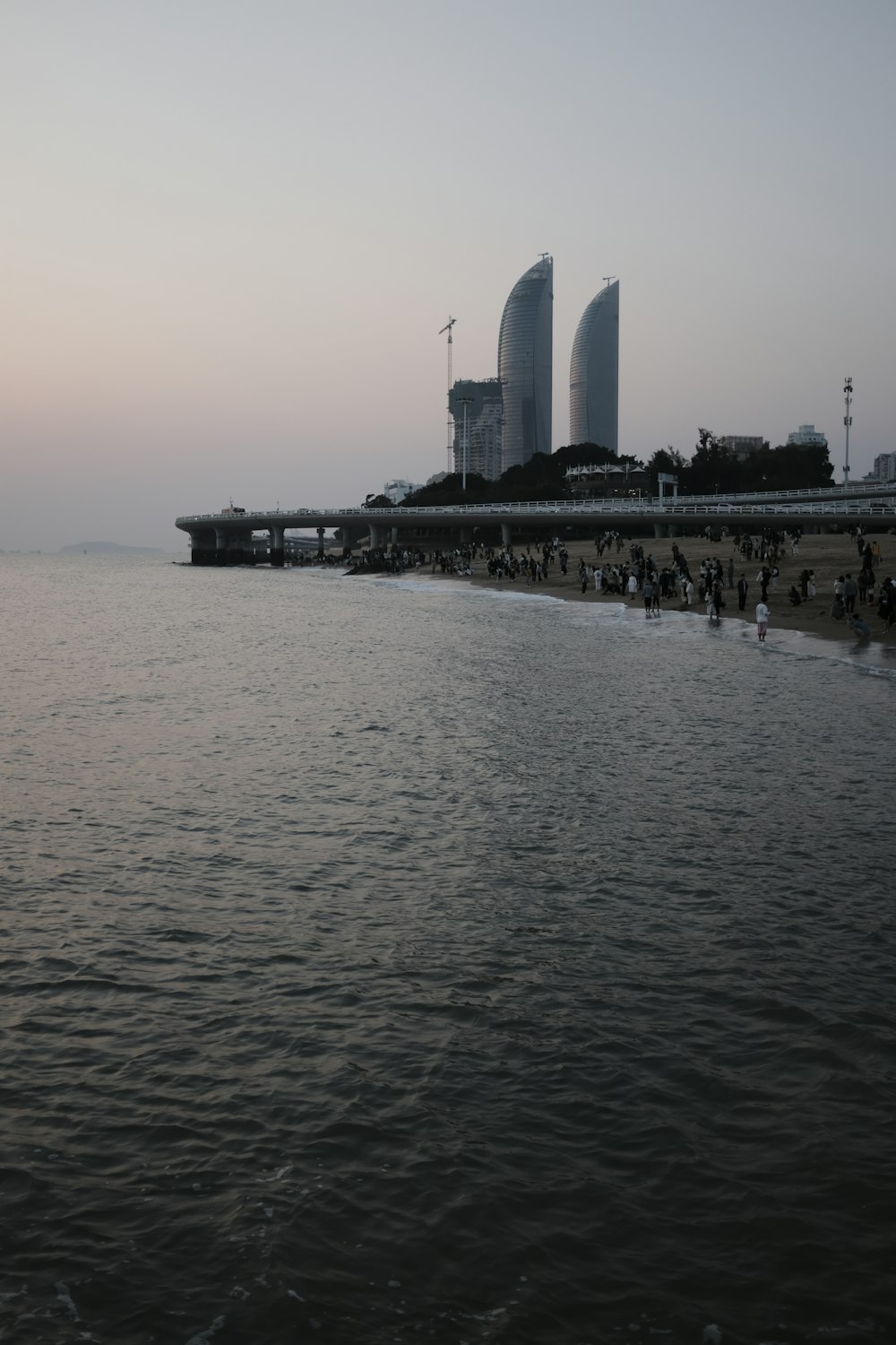 a body of water with a pier and buildings in the background