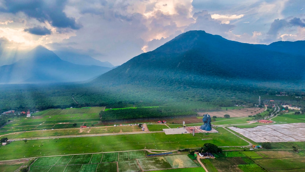 a large green landscape with a mountain in the background