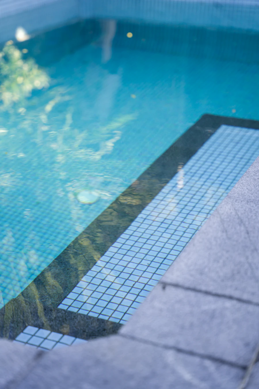 Sparkling pool water with blue mosaic tiles