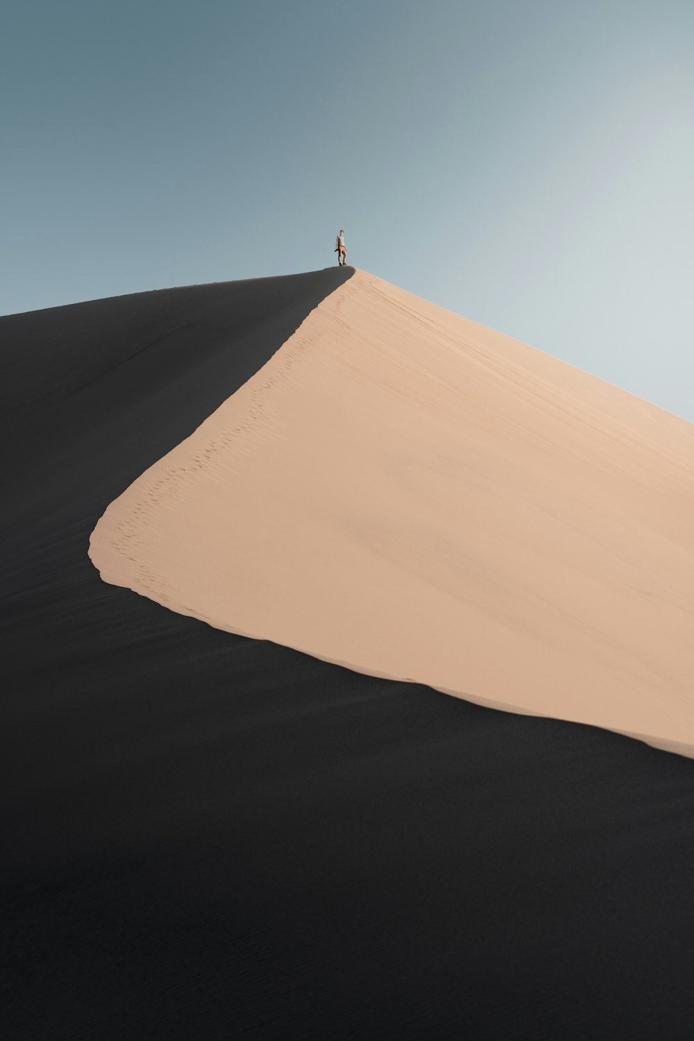 a person standing on a sand dune