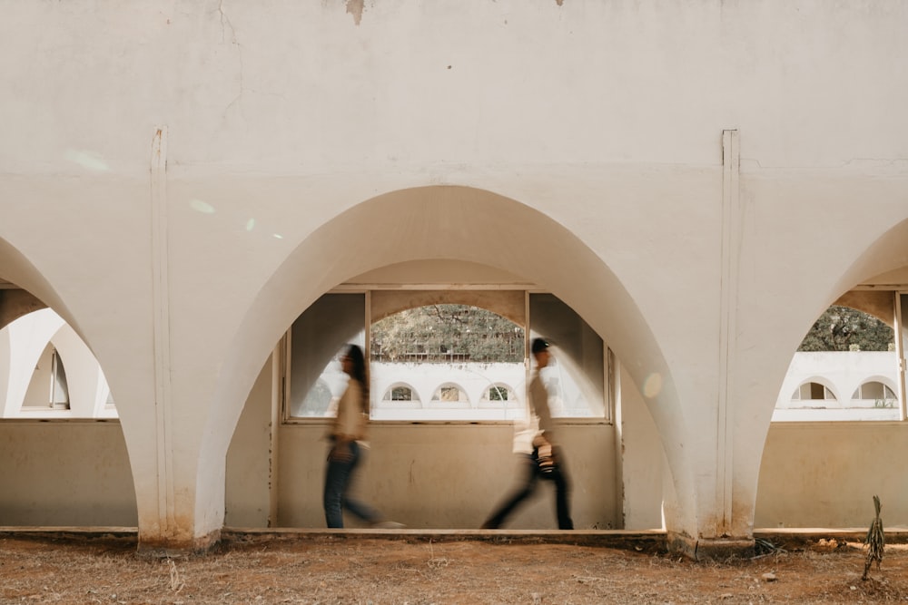 a couple of people walking through a building