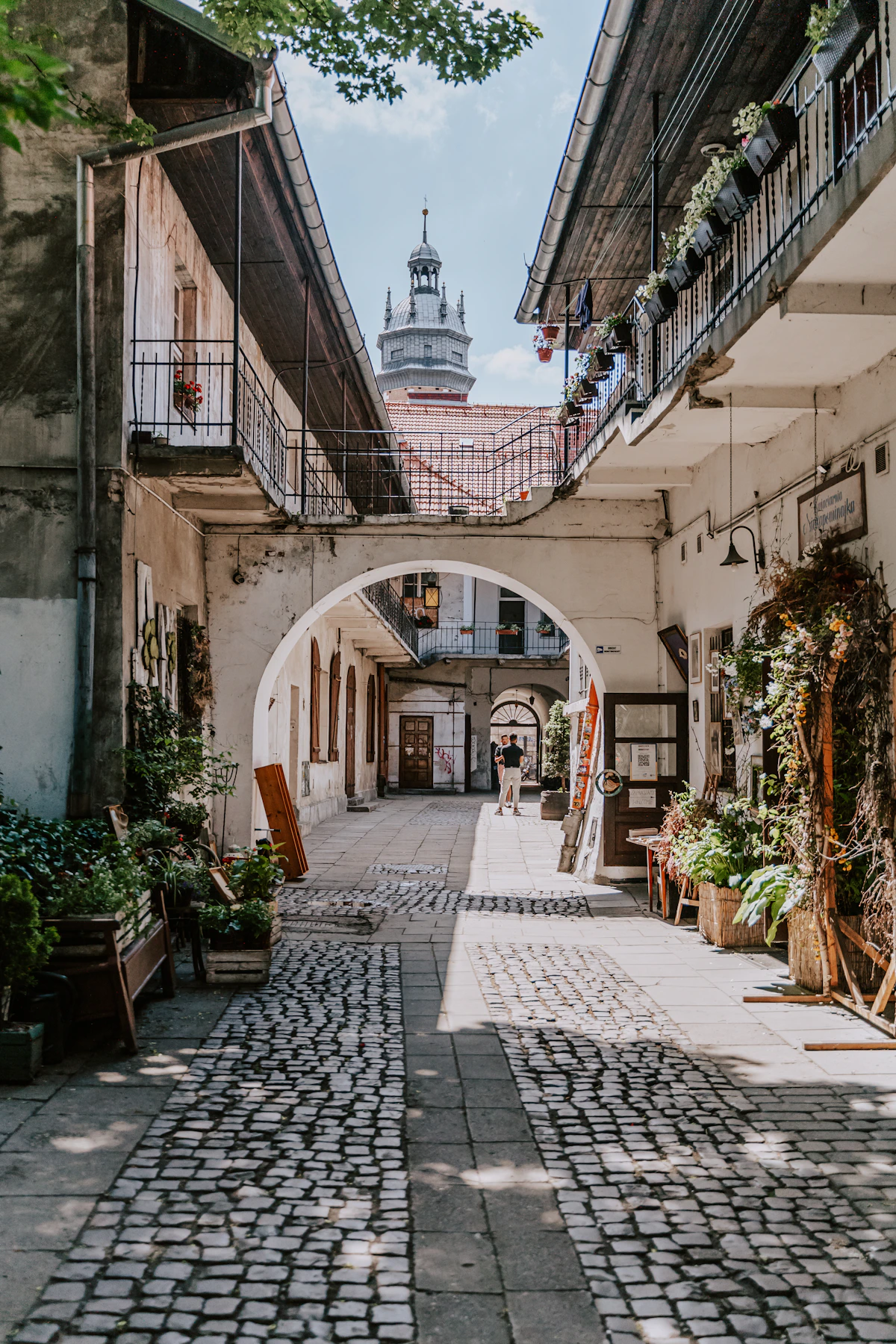 A sunlit cobbled courtyard and passage in Kraków's Kazimierz district