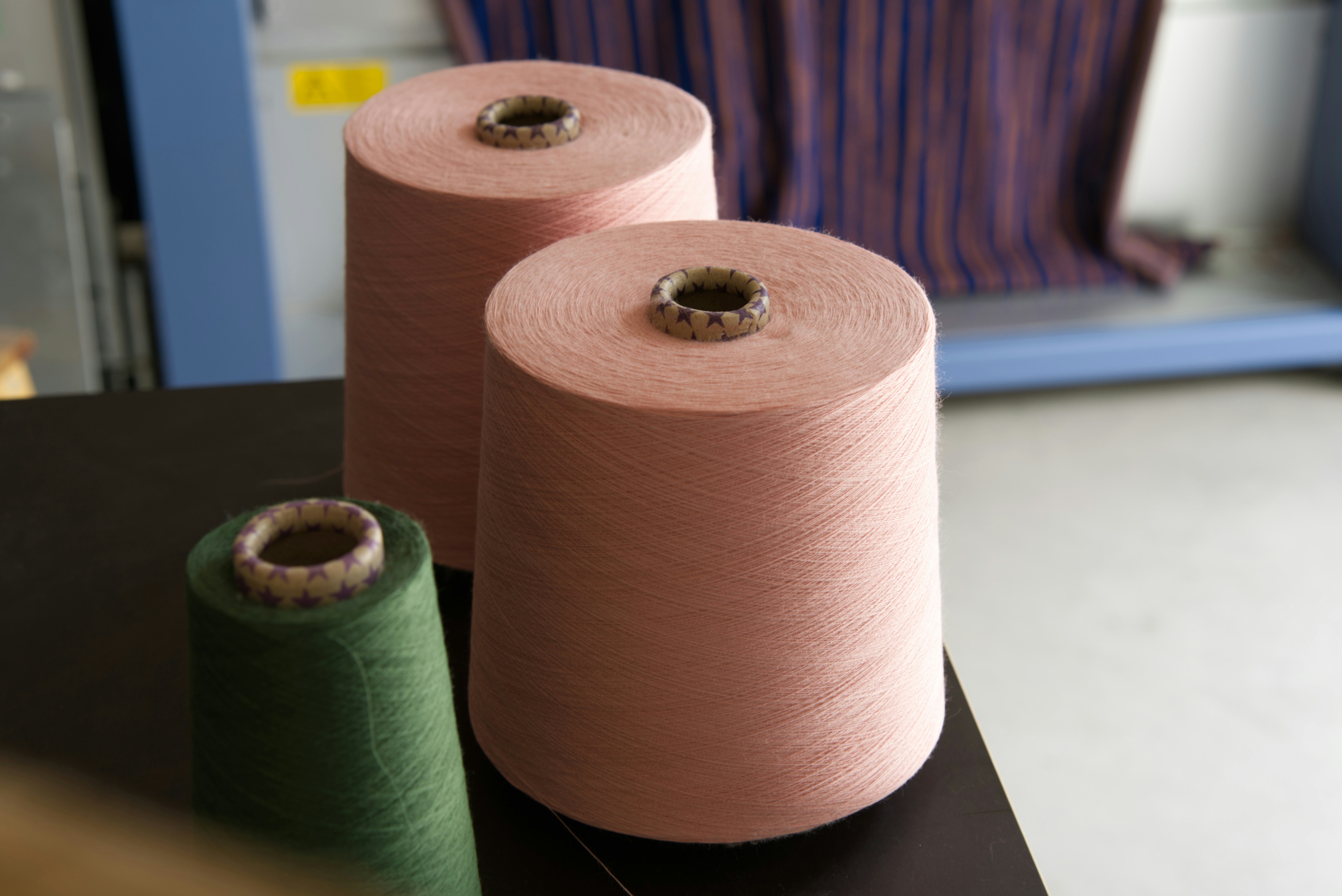Spools of pink and green organic cotton yarn used in beach towel production at Towel.Studio, Berlin Germany.