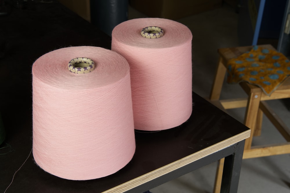 a couple of pink vases on a table