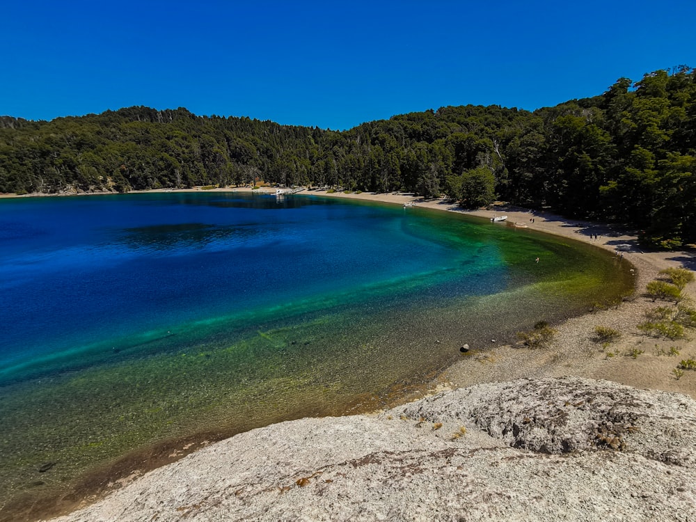 a blue lagoon with trees and hills