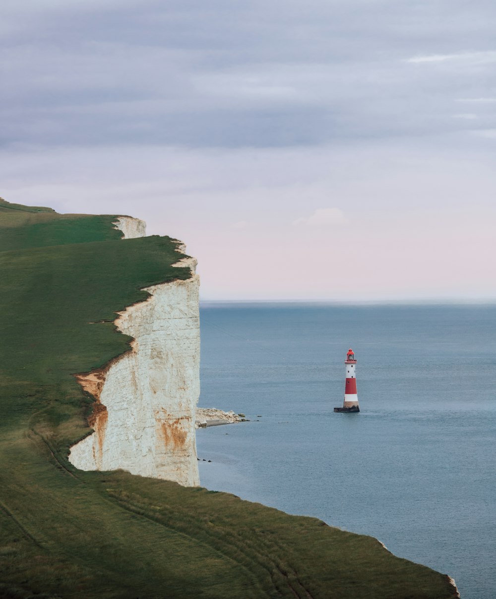 a lighthouse on a cliff with Beachy Head in the background