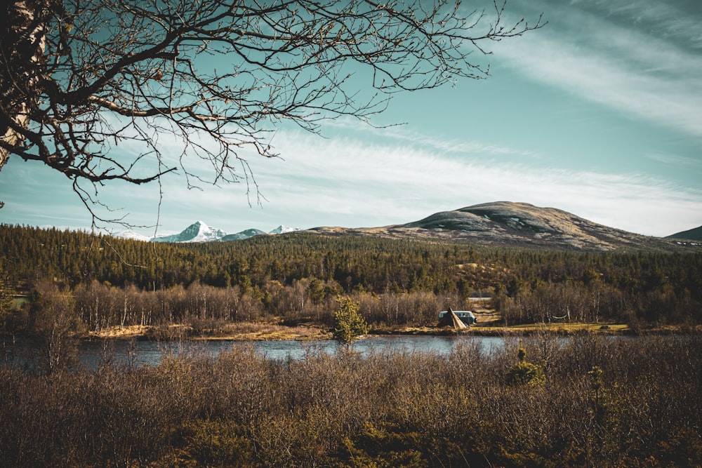 a lake with a house and mountains in the background