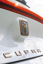 Close-up of carbon fiber car accessories and stylish decals on a sleek Cupra vehicle.