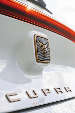 Close-up of carbon fiber car accessories and stylish decals on a sleek Cupra vehicle.
