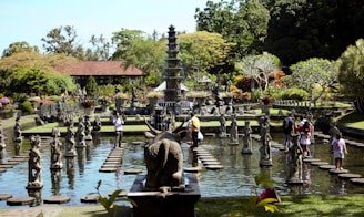 a group of people standing around a fountain with statues in it