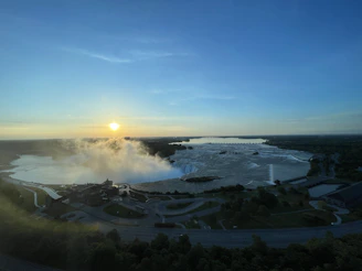 A breathtaking view of Victoria Falls with mist rising over the Zambezi River at sunset.