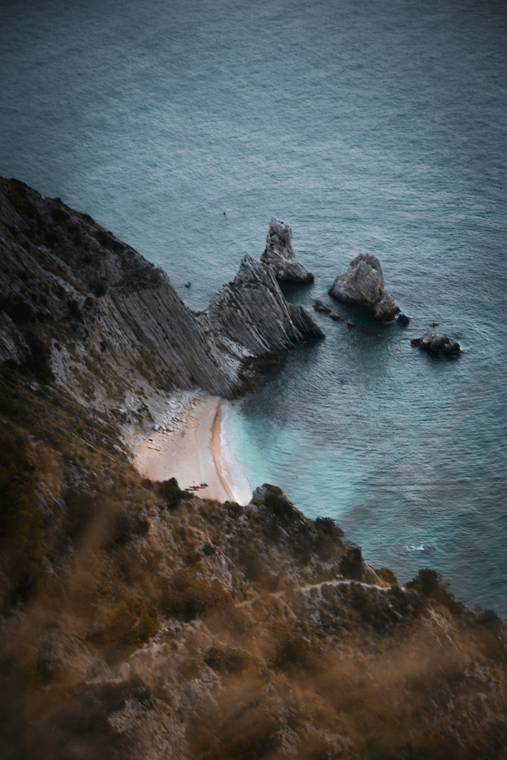 a rocky cliff with a body of water below