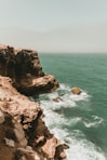 a rocky cliff next to the ocean