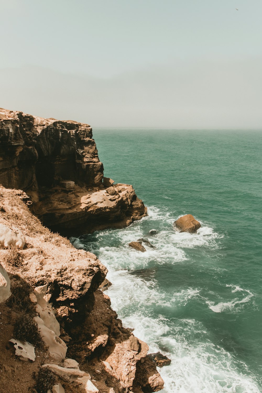 a rocky cliff next to the ocean