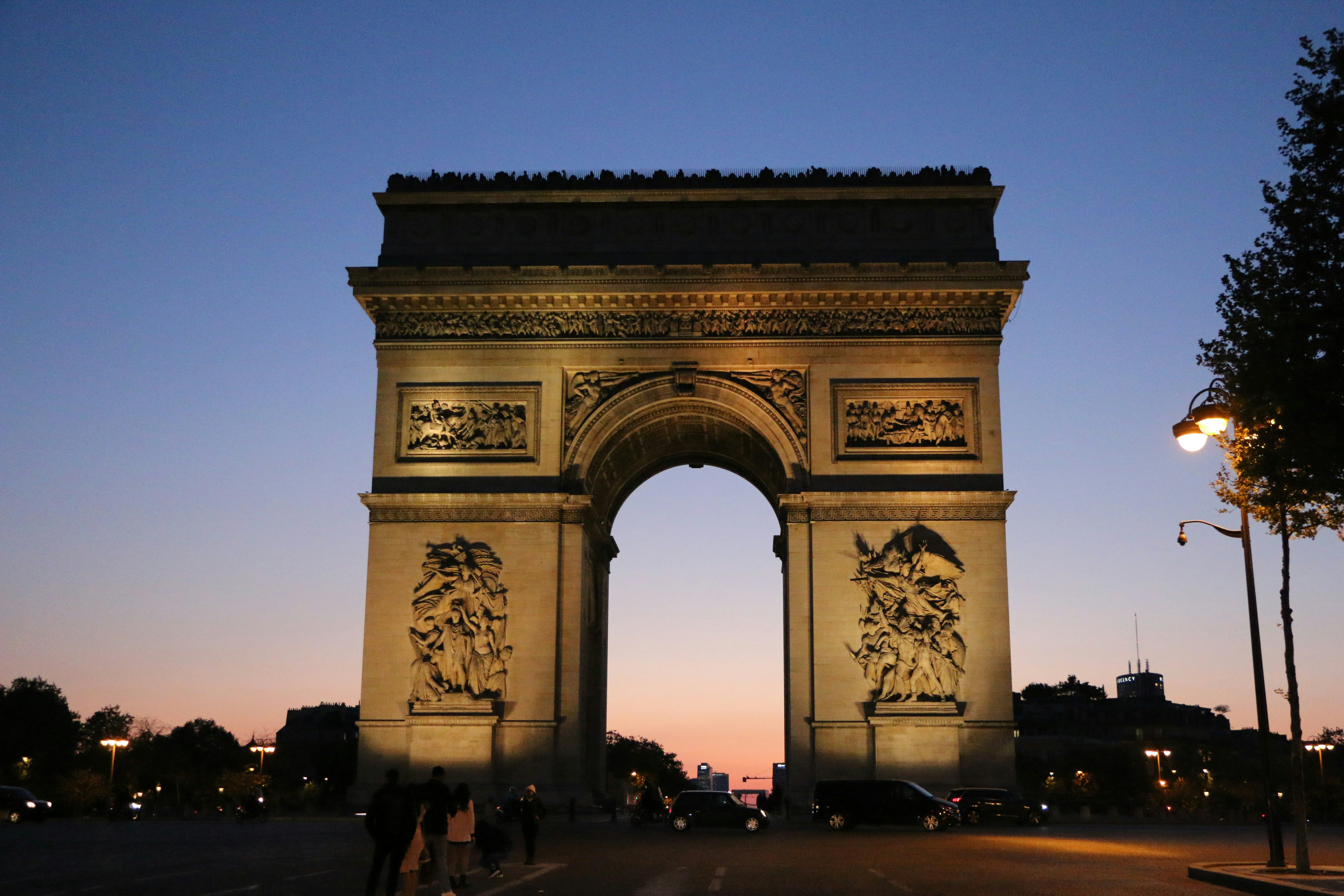 A large stone arch with a statue on top with Arc de Triomphe in the ...