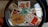 A collection of Indian postal stamps viewed through a magnifying glass. The stamps feature various designs, including architectural landmarks, artwork, cultural symbols, and portraits. The magnifying glass emphasizes the details and intricacies of the stamp designs.