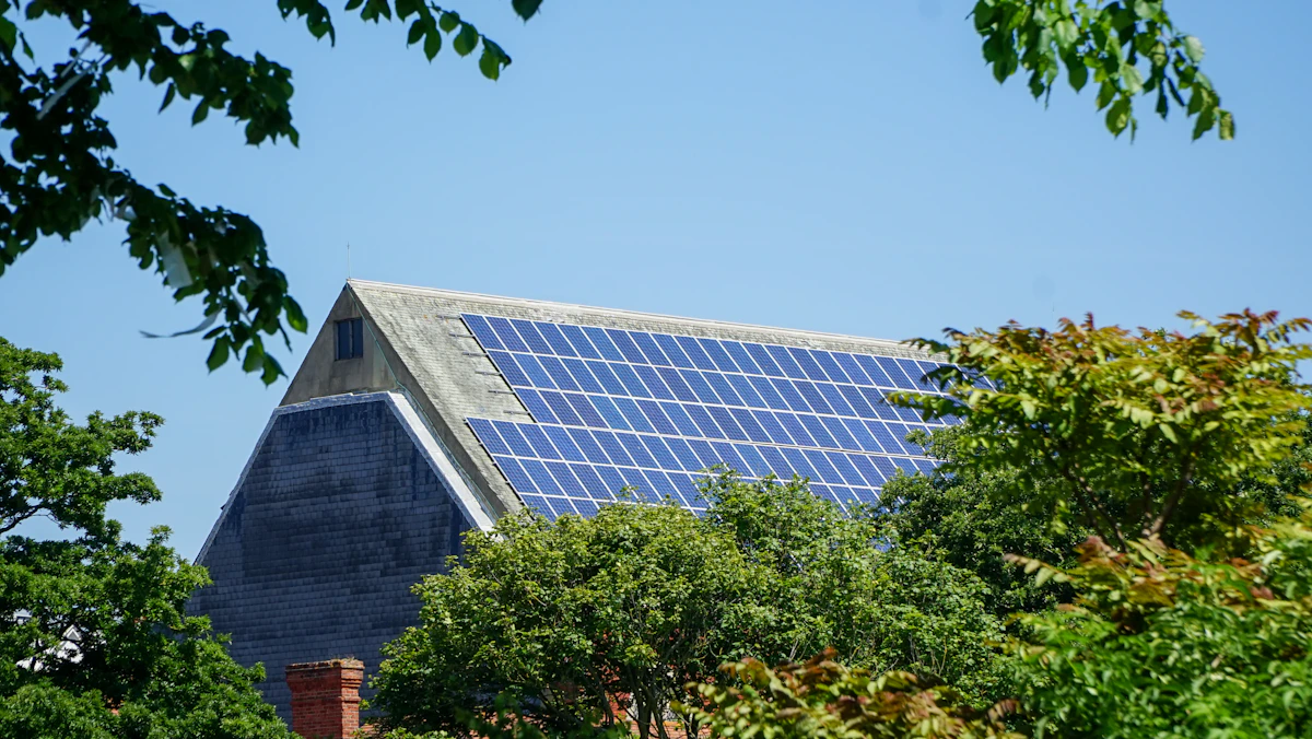 Casa com painéis solares instalados no telhado entre árvores
